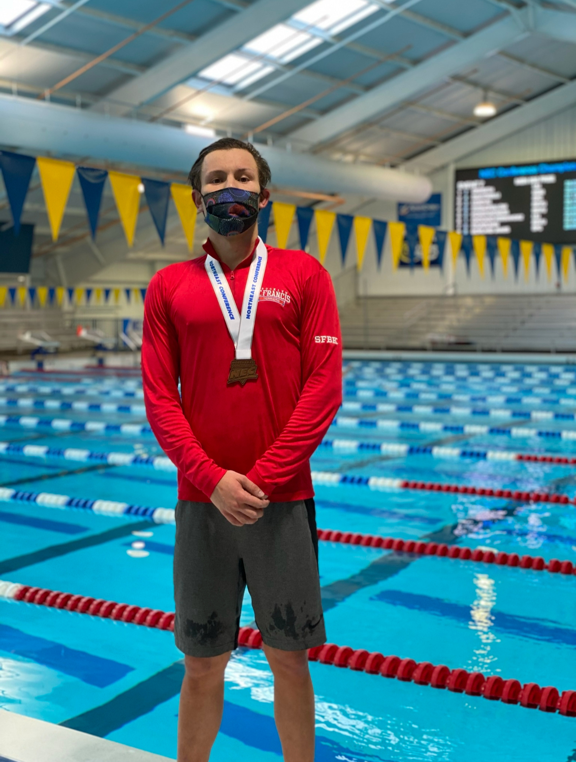 Benedek wearing a medal at a swimming venue